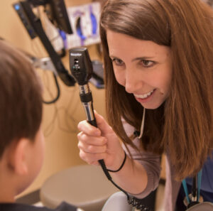 Pediatrician giving an eye exam to a child