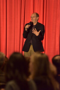 Comedian on stage at Lunch and Laughter