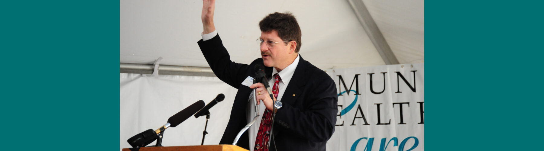David Flentge stands at a podium gesturing as he speaks to a crowd